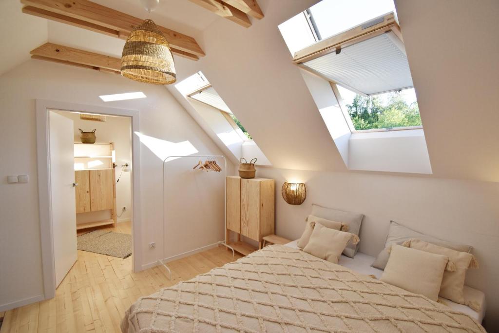a bedroom with a bed in a room with skylights at Morze Las in Ustka