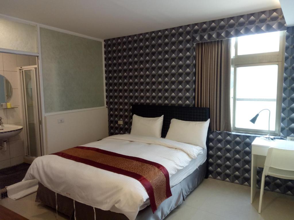 a bedroom with a large bed and a table at Hai Gang Yuan Homestay in Kenting