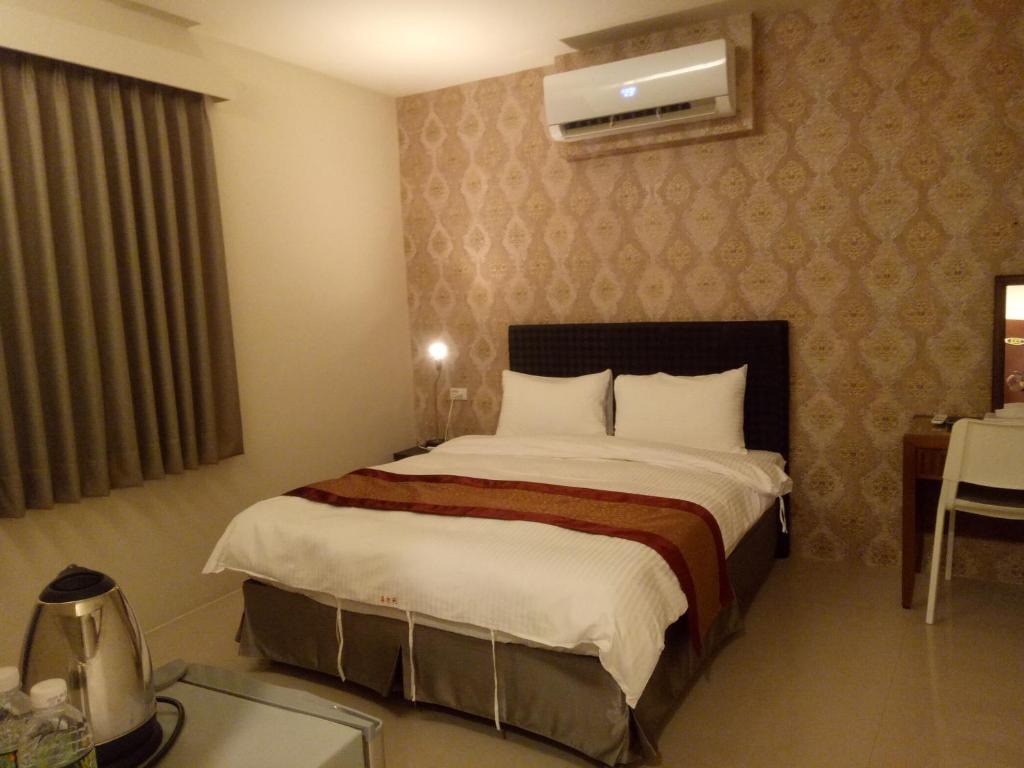 a bedroom with a large bed in a hotel room at Hai Gang Yuan Homestay in Kenting