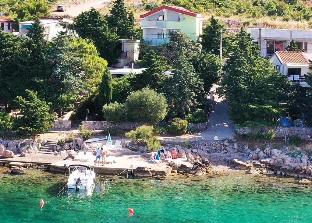 a group of people on a beach in the water at Apartmani Vila Dadić in Karlobag