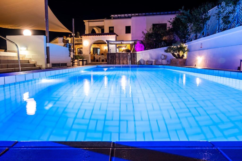 una grande piscina notturna con luci accese di D View 4 You a Mellieħa