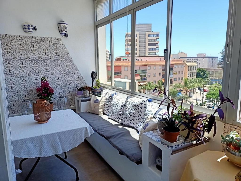 a living room with a couch and a large window at San Enrique - City life in Torremolinos