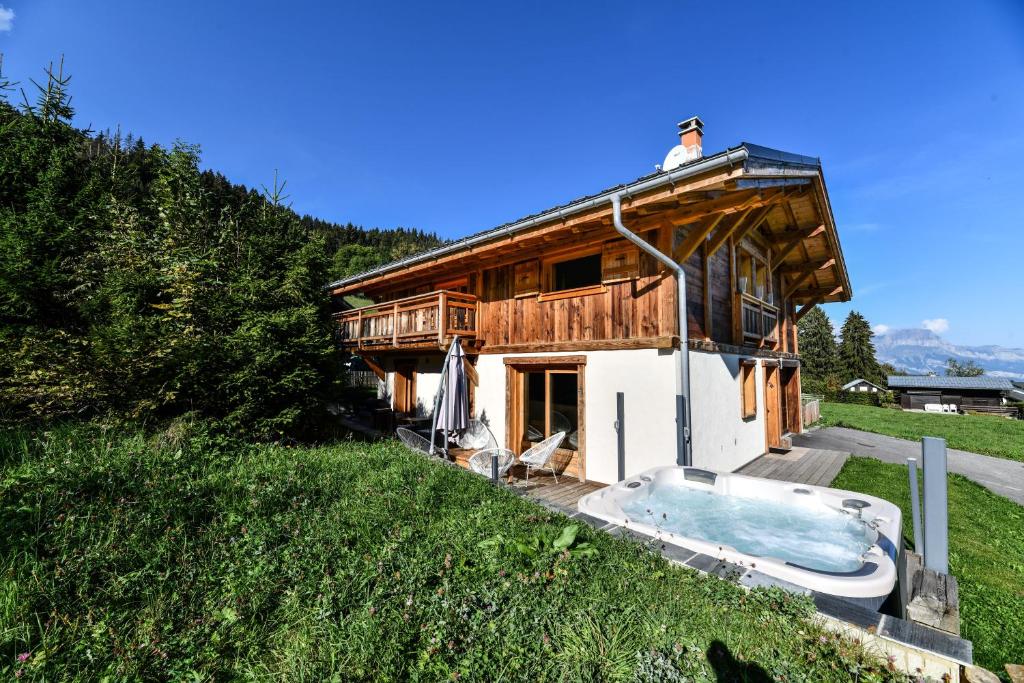 uma casa com uma banheira em frente em Vielyterra - Chalet haut de gamme - Domaine du mont blanc em Saint-Gervais-les-Bains