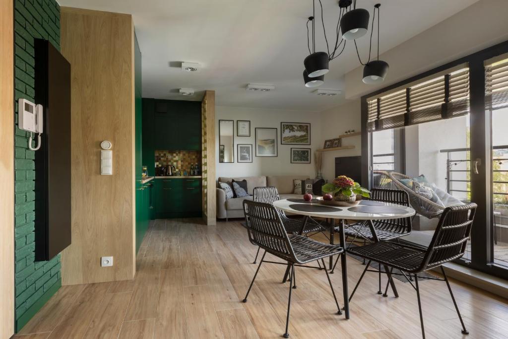 uma sala de jantar e sala de estar com mesa e cadeiras em Wine Apartment Gdynia em Gdynia