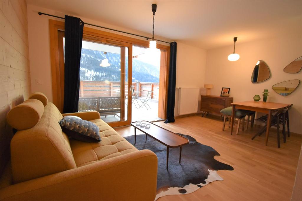 a living room with a couch and a table at VAUJANYLOCATIONS - La Cabane de Maurice in Vaujany