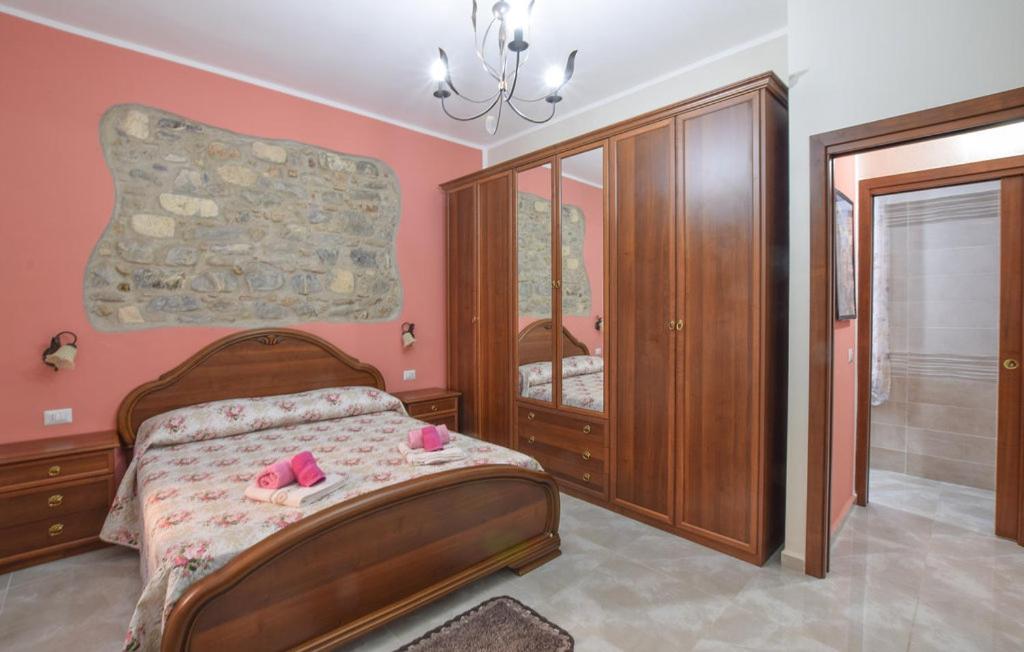 1 dormitorio con 1 cama con paredes de color rosa en La casetta di nonna Maria, en Villapiana