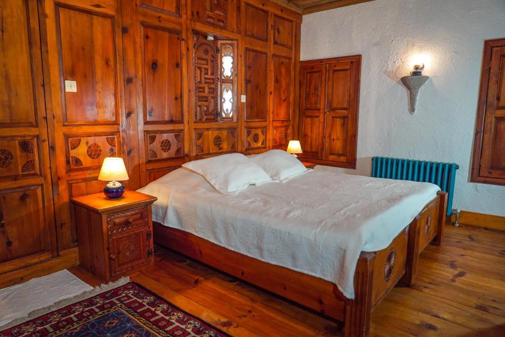 1 dormitorio con 1 cama grande con paneles de madera en Biber Evi Assos, en Ayvacık