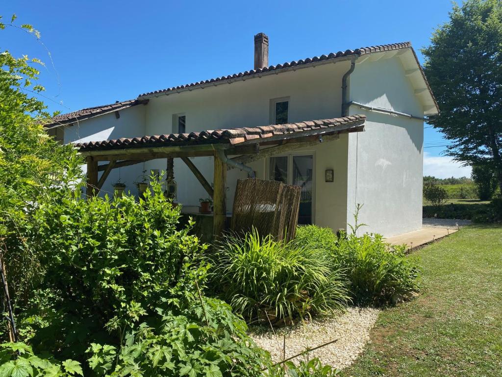 a small white house with a pergola at Gite Les Justices in Édon