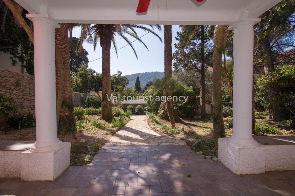 un chemin avec des palmiers et un bâtiment dans l'établissement Red House Veli Lošinj, à Veli Lošinj