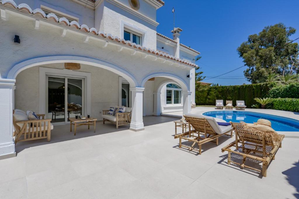 eine Terrasse mit Stühlen und einem Pool in der Unterkunft Brisa del Mar - Managed by Almarina in Benissa