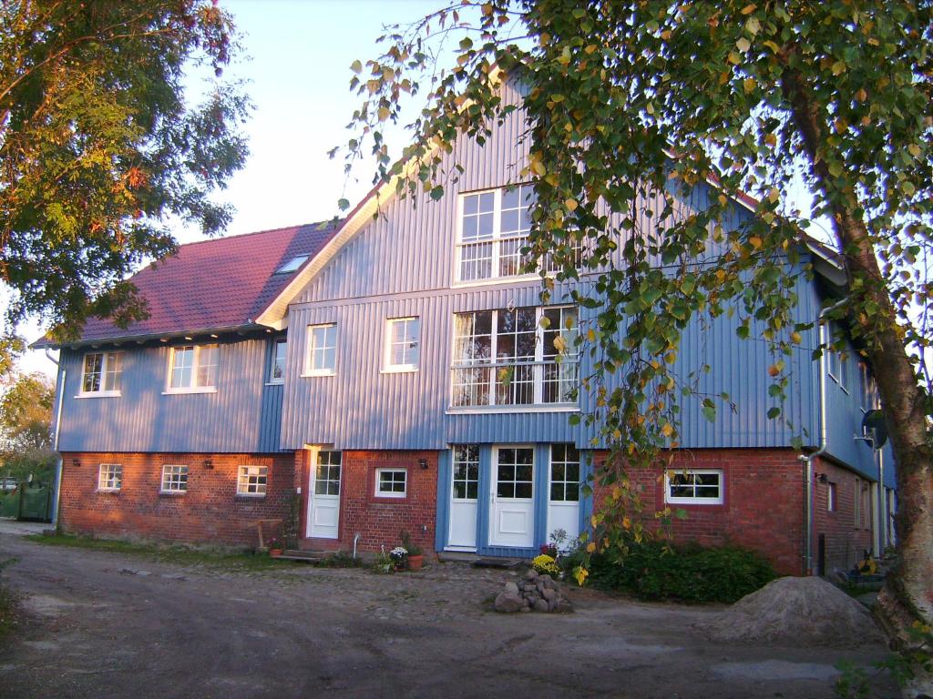 um grande edifício de tijolos vermelhos com um telhado azul em Ferienhof - Rauhenberg em Wangels