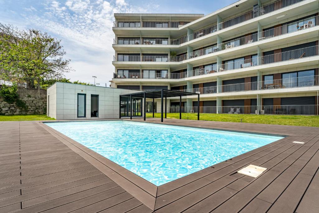 a large swimming pool in front of a building at Antas Park Apartment in Porto