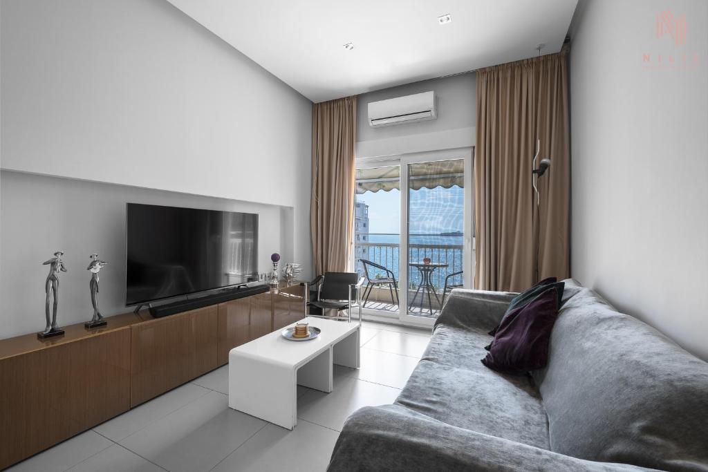 a living room with a couch and a tv at Awesome Sea View, Nilie Hospitality MGMT in Thessaloniki