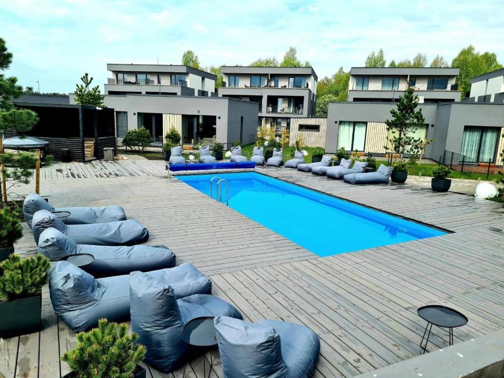 a swimming pool with chaise lounges and a resort at Mikis apartament, Mano Jūra 2, Kunigiškiai in Palanga