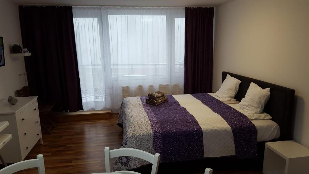een slaapkamer met een bed met een paarse en witte deken bij Appartement Grün-Weiß in Sankt Englmar