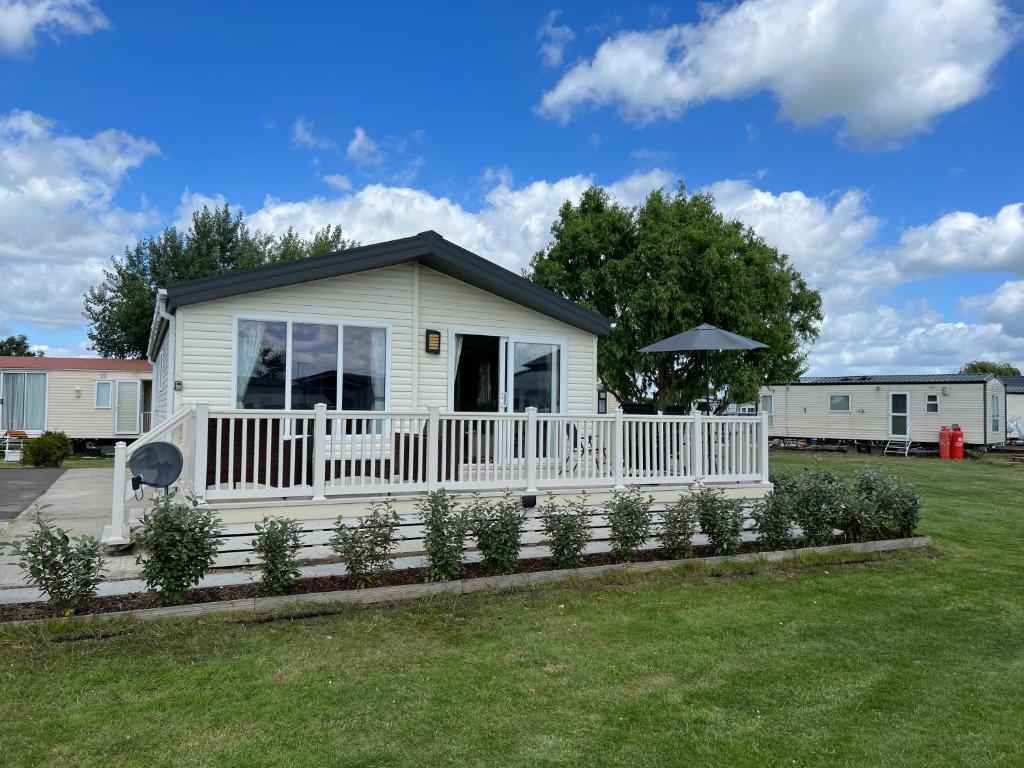 a small white house with a white fence at Steeple Bay Lodge in Steeple