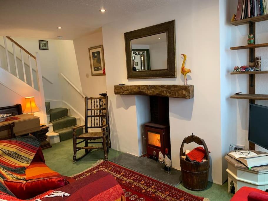 a living room with a fireplace and a mirror at Cosy holiday cottage in Crickhowell. in Llangattock