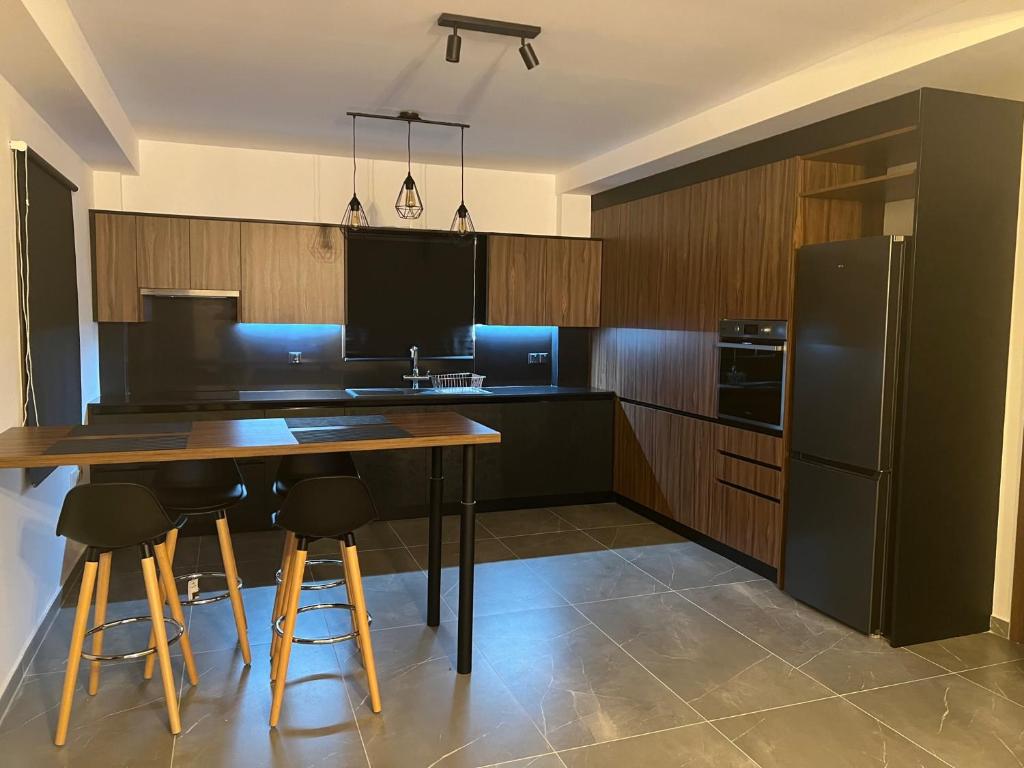 eine Küche mit einem Holztisch und einem schwarzen Kühlschrank in der Unterkunft Maria's Apartments 1 in Galata