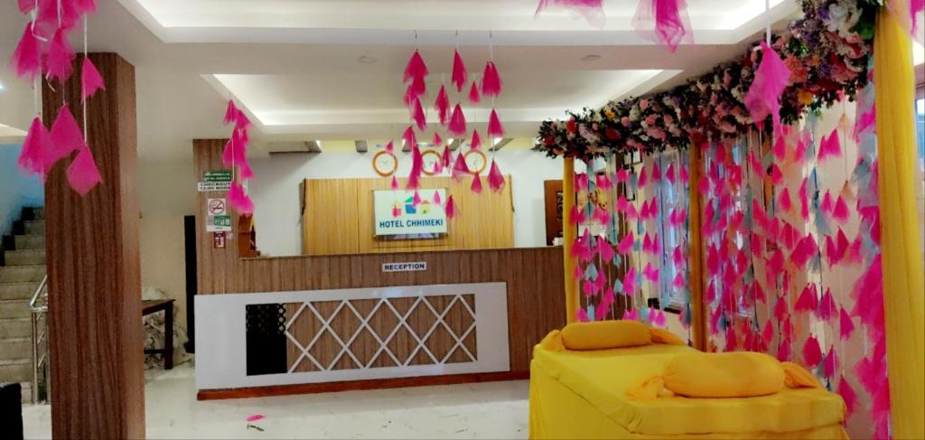 un soggiorno con decorazioni rosa e una porta con camino di Hotel Chhimeki a Kathmandu