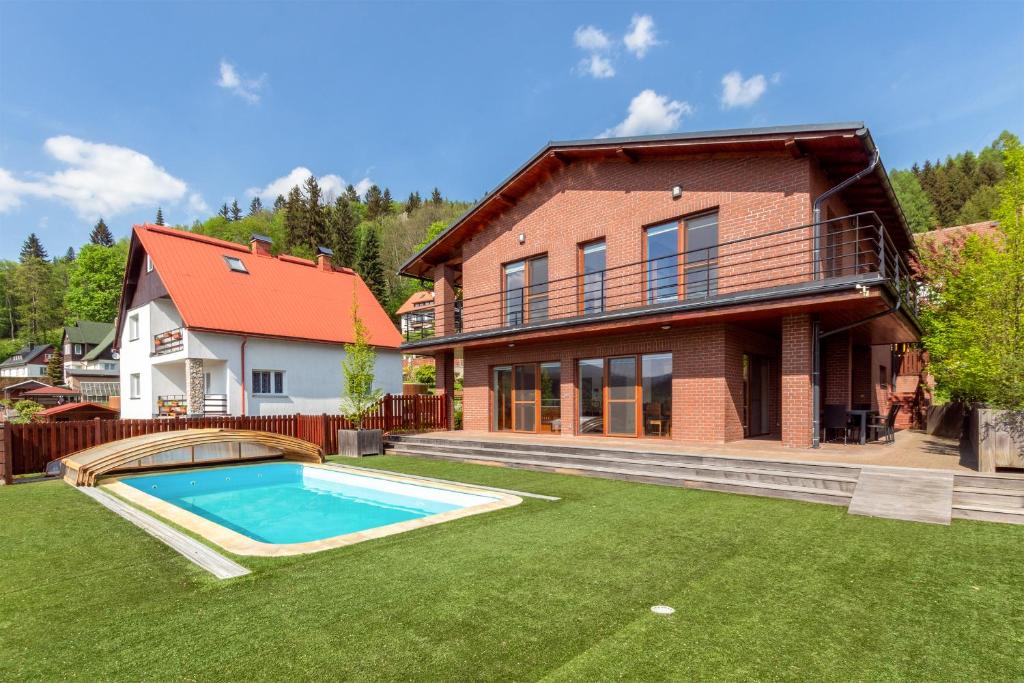 une maison avec une piscine dans la cour dans l'établissement Vila Sluneční stráň, à Svoboda nad Úpou