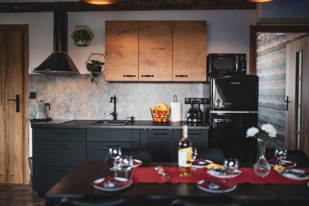 a kitchen with a black refrigerator and a table at Prestige 2 in Łeba