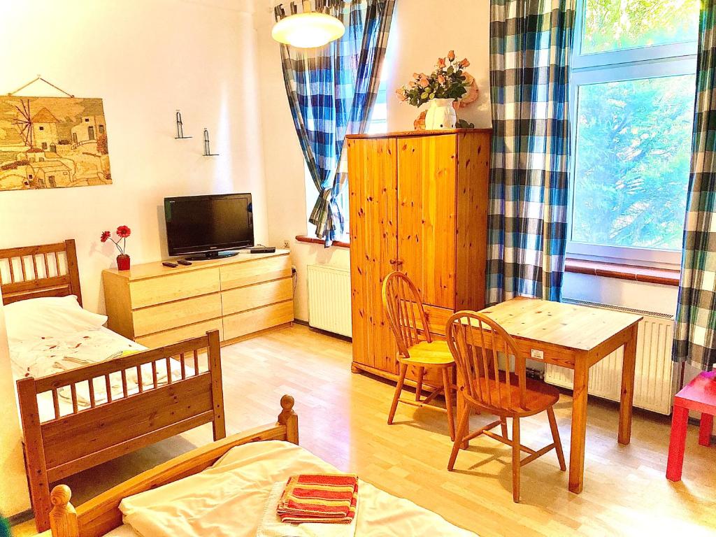 ein Wohnzimmer mit einem Tisch und ein Schlafzimmer in der Unterkunft Apartment Liesingbach in Wien