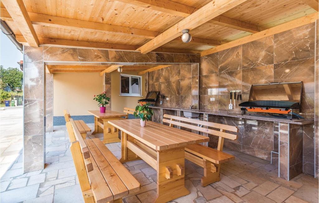 patio z drewnianym stołem i ławkami w obiekcie Apartment Medulin 04 w Medulinie
