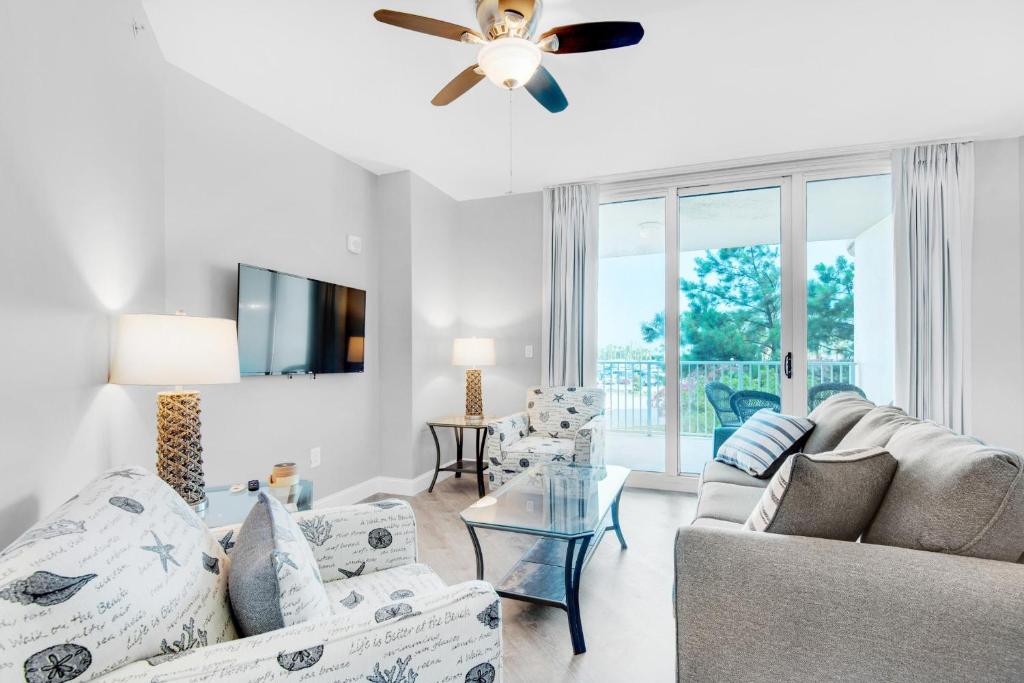 een woonkamer met witte meubels en een plafondventilator bij Palms Resort #1202 Full 2 Bedroom in Destin