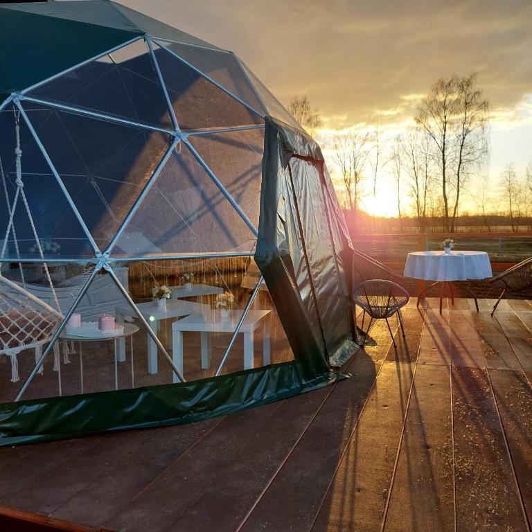 une tente sur une terrasse avec une table. dans l'établissement DebessJums, à Nereta