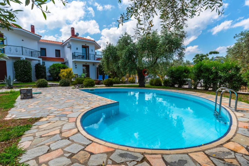 a swimming pool in a yard with a house in the background at Villa Nostalgia in Skala Potamias