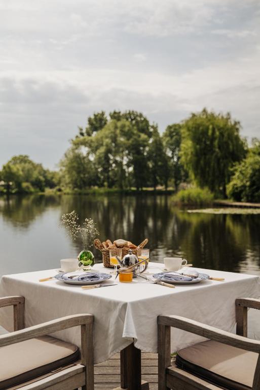 a table with food and a view of a lake at Inn on the Lake in Broek in Waterland
