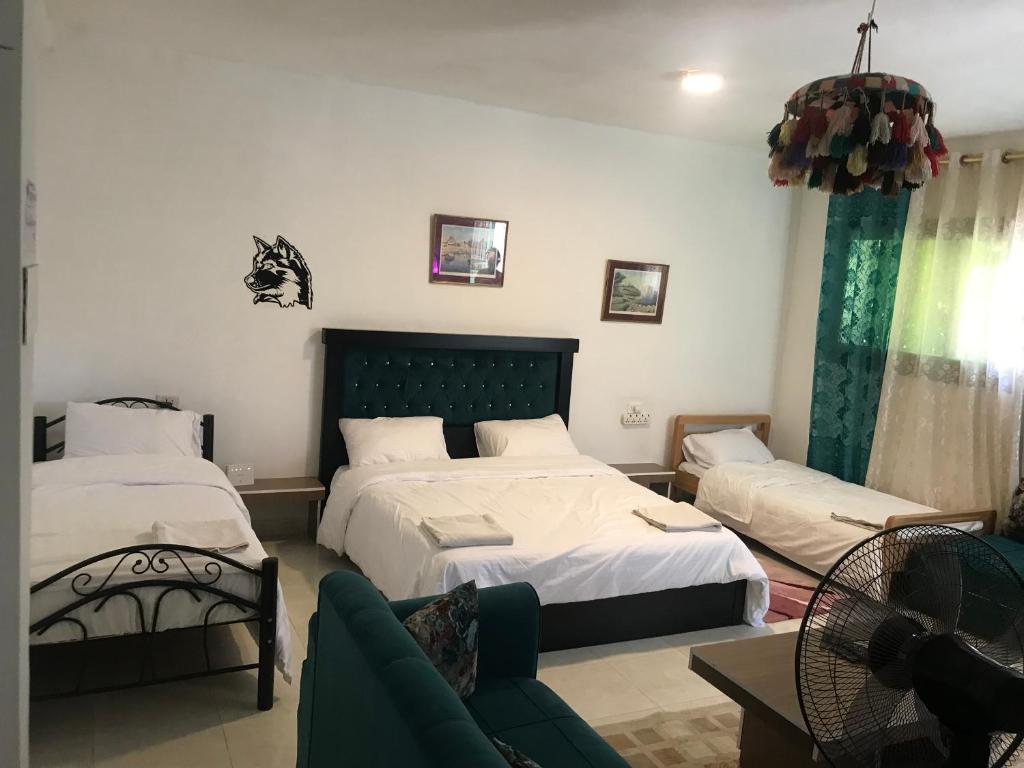 1 dormitorio con 2 camas y sofá en La Bella BedoUina, en Wadi Musa