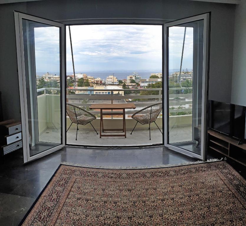 a room with a table and chairs on a balcony at Panoramic Apartment in Chios