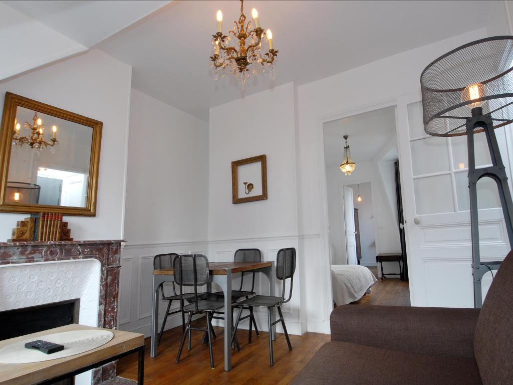 a living room with a table and chairs and a chandelier at Appart'Tourisme Paris Porte de Versailles in Paris