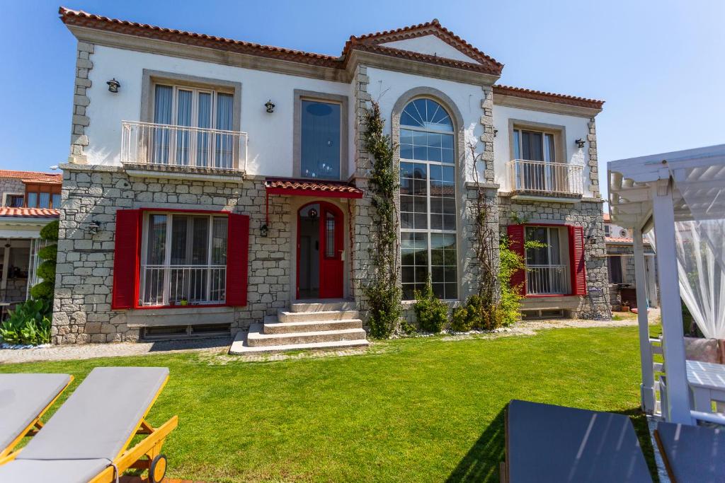 a house with a red door and a yard at Kokopelli Alacati in Alaçatı