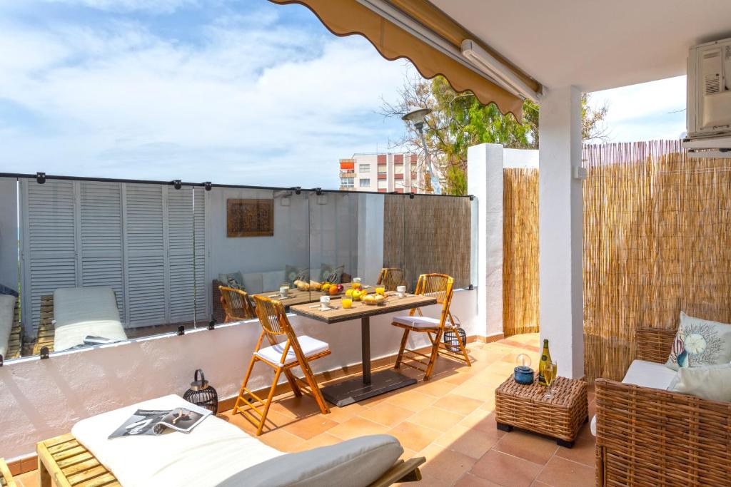 patio con mesa y sillas en el balcón en Livemálaga San Telmo Beach, en Málaga