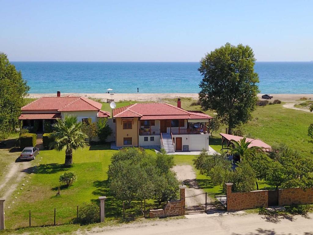 Villa Ilyos في إيريسوس: منزل على الشاطئ مع المحيط خلفه