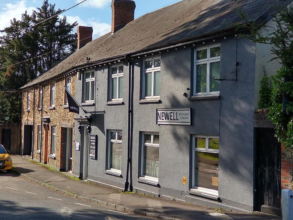 a gray building on the side of a street at Newell Bistro and Rooms in Sherborne