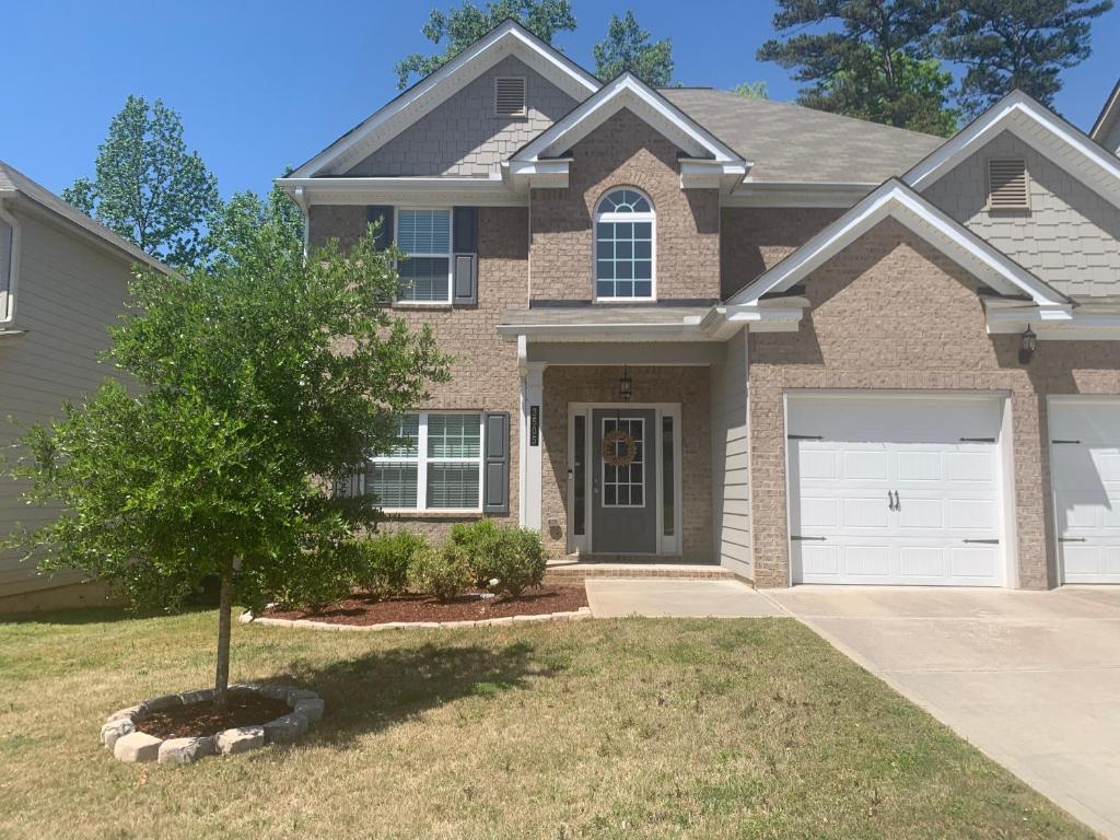a house with a tree in the front yard at Private, quiet, immaculate bachelor pad with free parking on site in Decatur