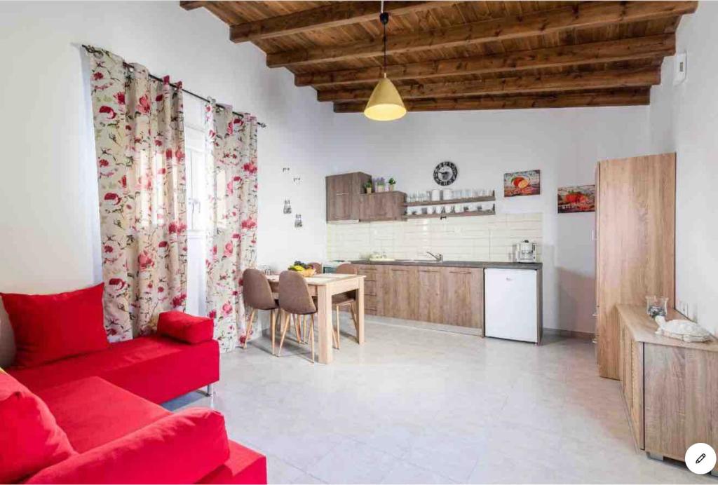 a living room with a red couch and a kitchen at Tertsa Casa Di Mare in Térsa