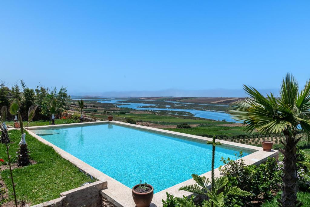 a swimming pool with a view of the ocean at La Villa Joubert in Oualidia