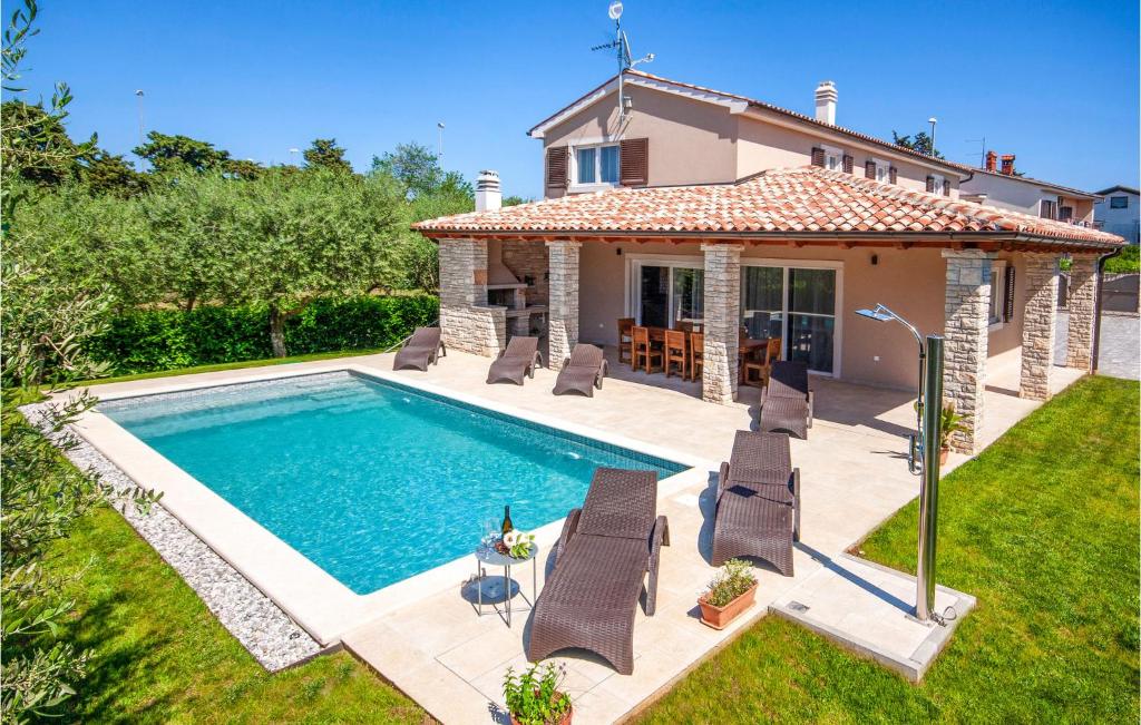 a villa with a swimming pool in front of a house at Lovely Home In Medulin With Wifi in Medulin