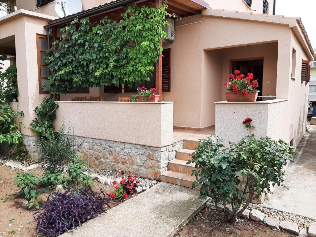 een huis met bloemen en planten ervoor bij Apartment Šare in Betina