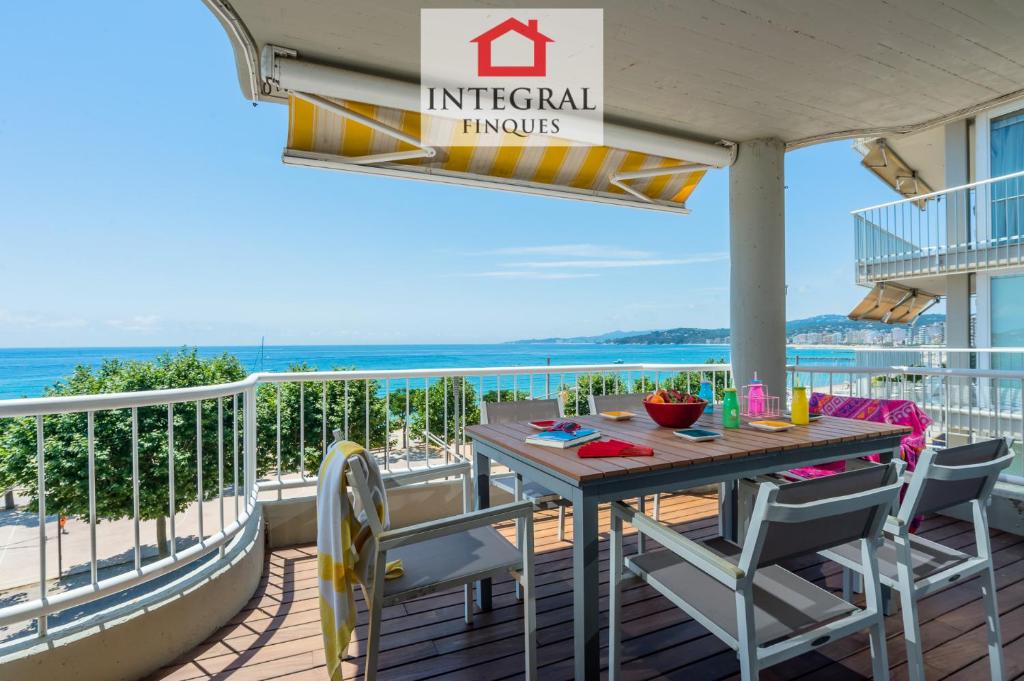 a table on a balcony with a view of the ocean at Ohana Apartament in Palamós