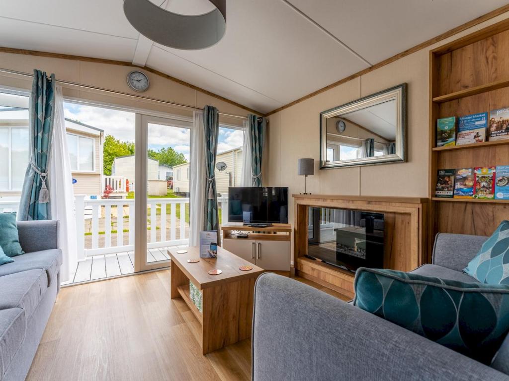 a living room with a couch and a tv at Pass the Keys Luxury brand new 2 bedroom pet friendly caravan in Wimborne Minster