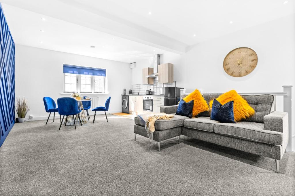 ein Wohnzimmer mit einem Sofa und einer Küche in der Unterkunft The Woodfield - stunning modern 2 bed apartment - TV in every bedroom! in Swansea
