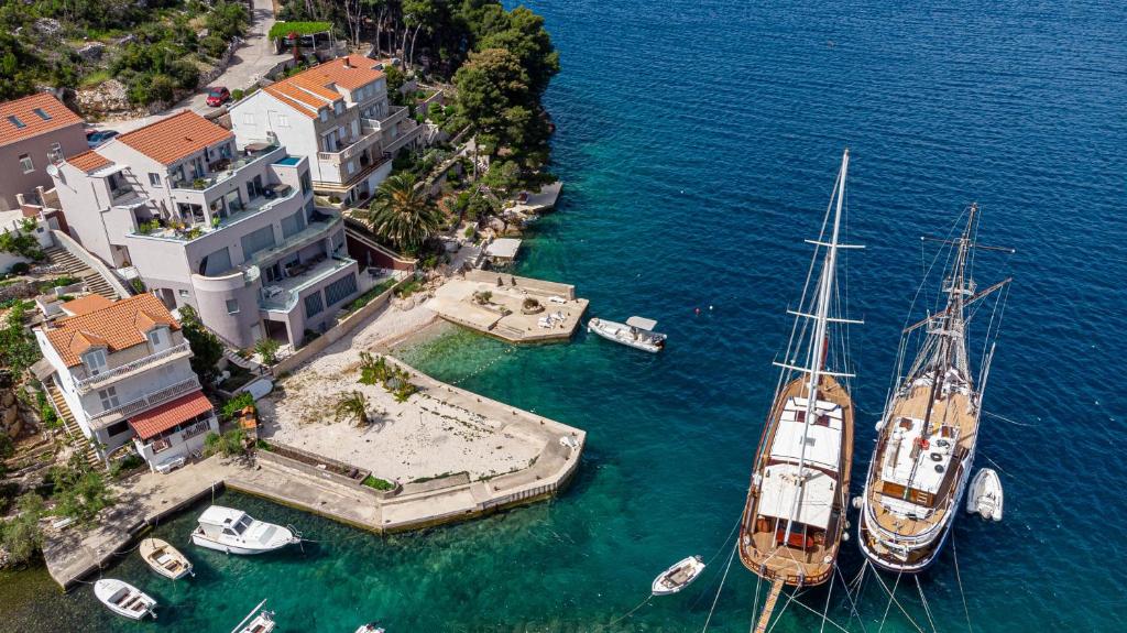 two boats are docked in the water next to a house at Suartini Apartmani Račišće in Račišće