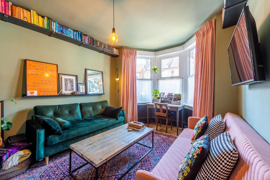 a living room with a green couch and a table at Pass the Keys Little Leyton Garden Flat in London