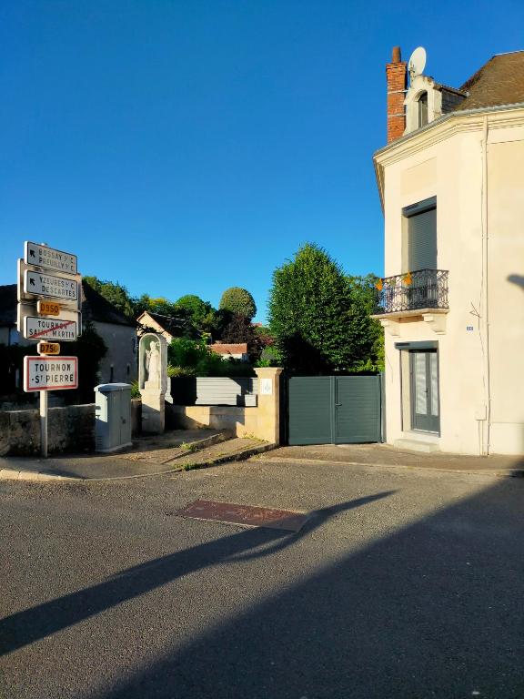 un panneau de rue devant un bâtiment blanc dans l'établissement Le Héron bleu de la Brenne, à Tournon-Saint-Martin