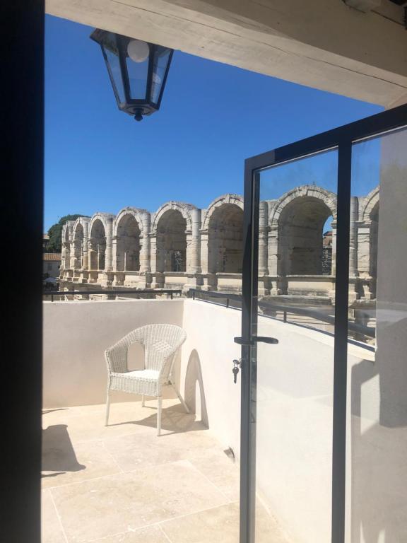 a chair on a patio with a view of a building at Entre les Arènes et la Major in Arles